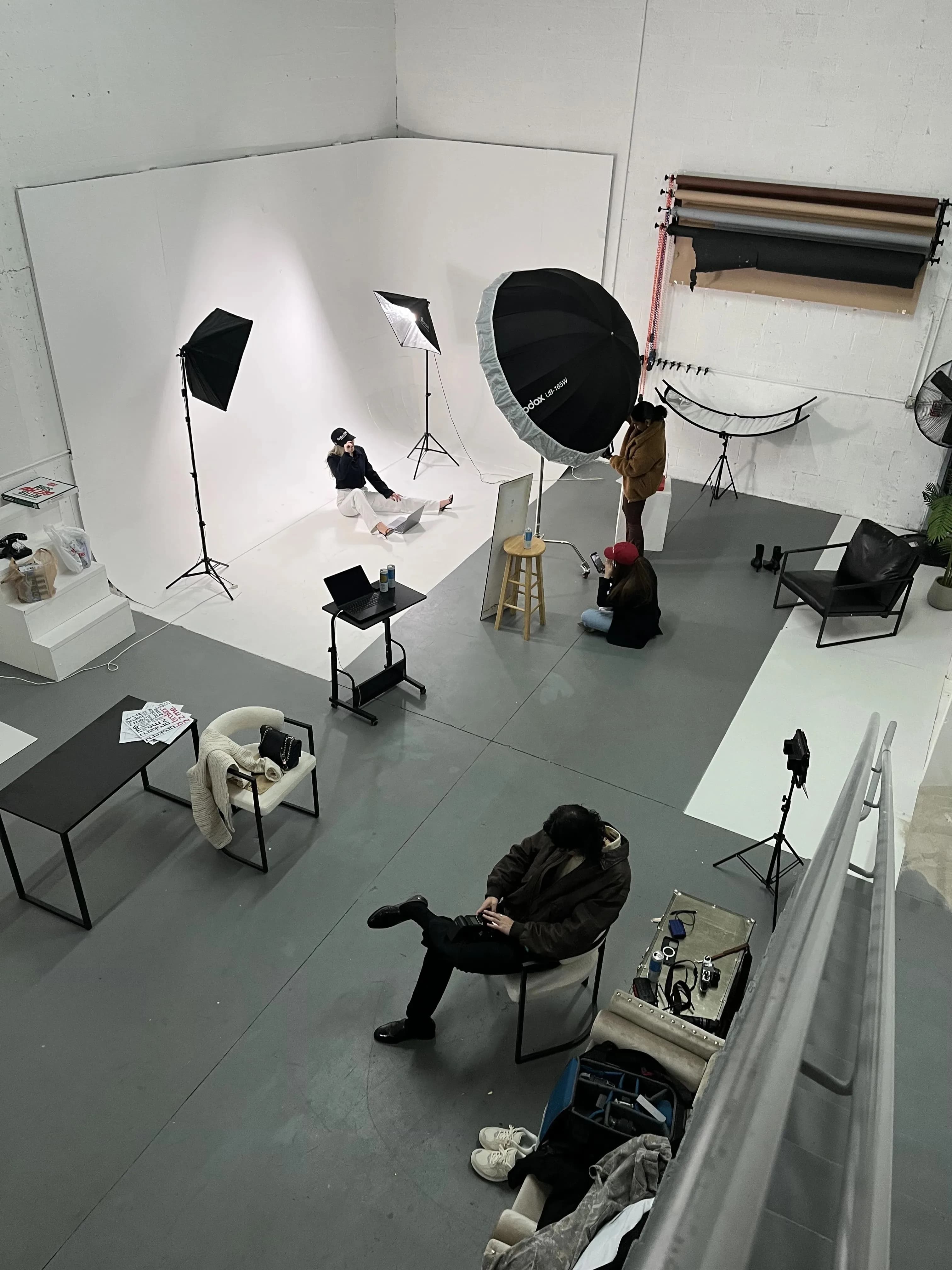 Overhead view of a Blank studio session — white cyclorama, softboxes, and crew between frames.