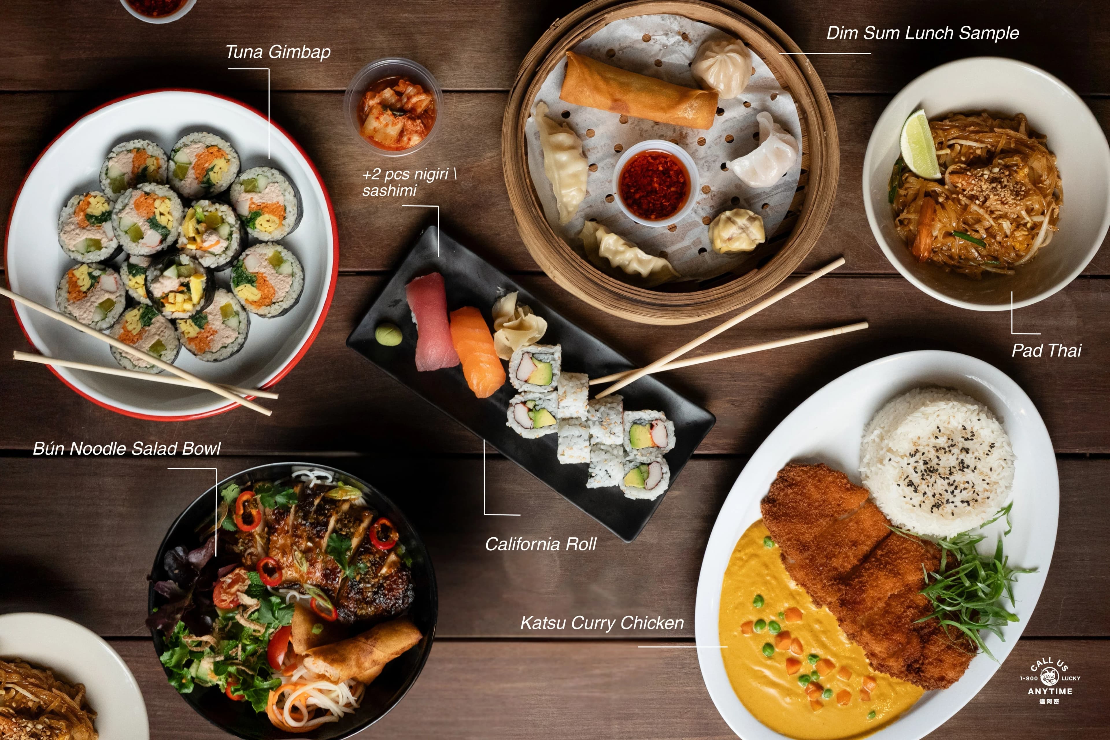 A 1-800-Lucky menu flat-lay labeling dishes across a dark wood table — tuna gimbap, dim sum, California roll, pad thai, katsu curry chicken, and a bún noodle salad bowl.